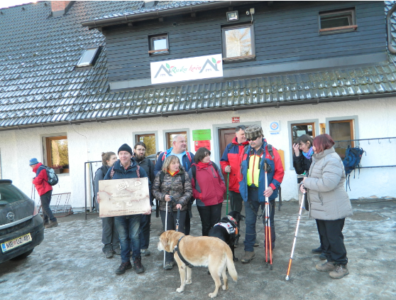 Na Ruški koči skupinska slika s taktilno tablo SSP po SPP, v ospredju sta dva psa, foto arhiv Pin/OPP